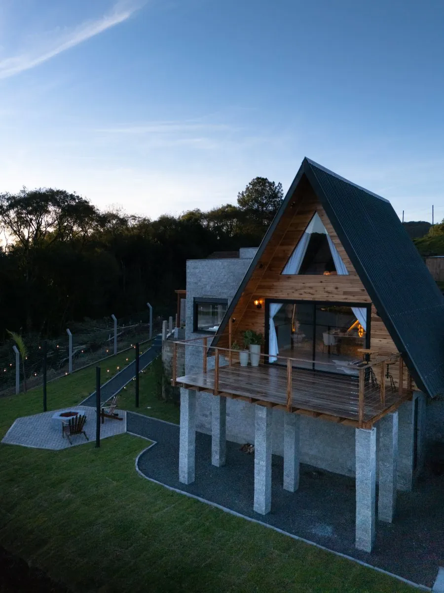 A Cabana Sonhos do Lago ao entardecer, com a sacada de madeira voltada para o lago